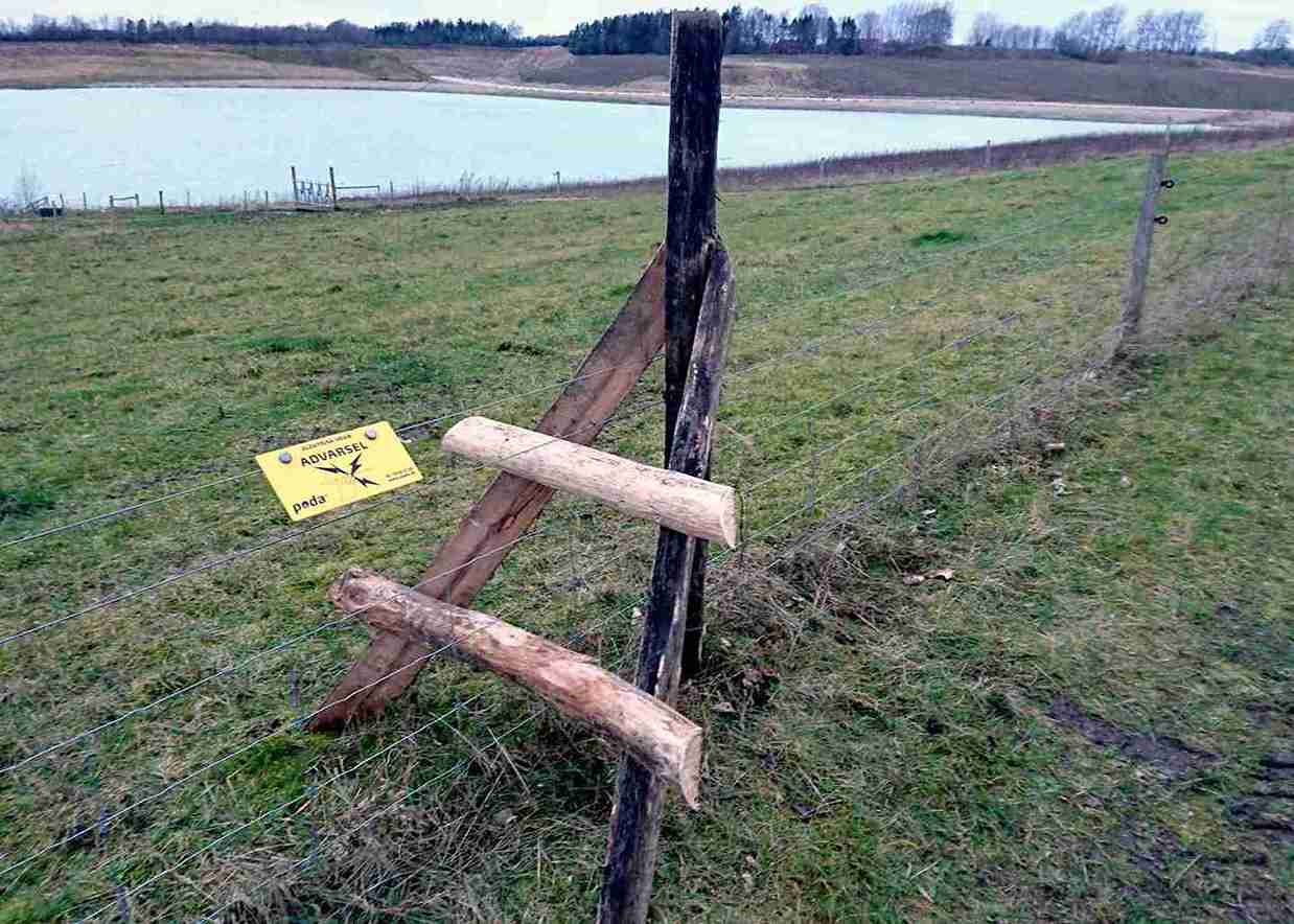 Een houten trap leidt van de ene kant van het hek naar de andere.