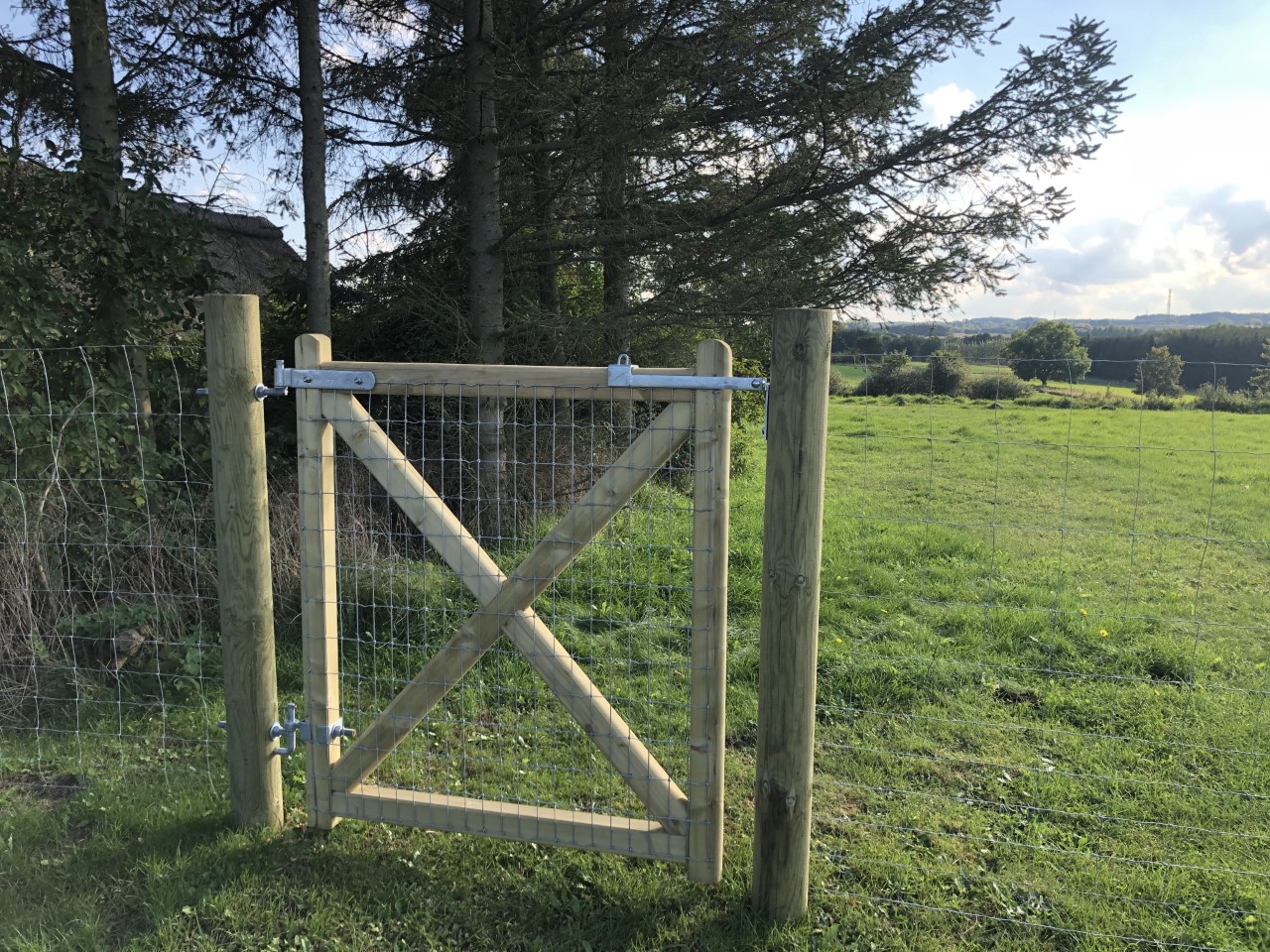 In het verlengde van een gaashekwerk is een Country Estate poort geïnstalleerd