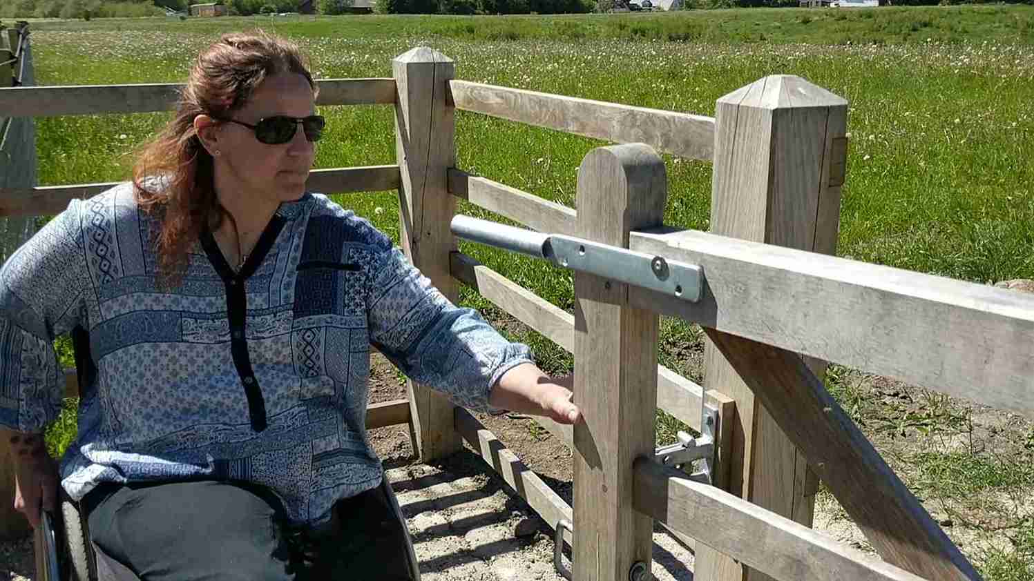 Een dame opent de poort van een HandyGate