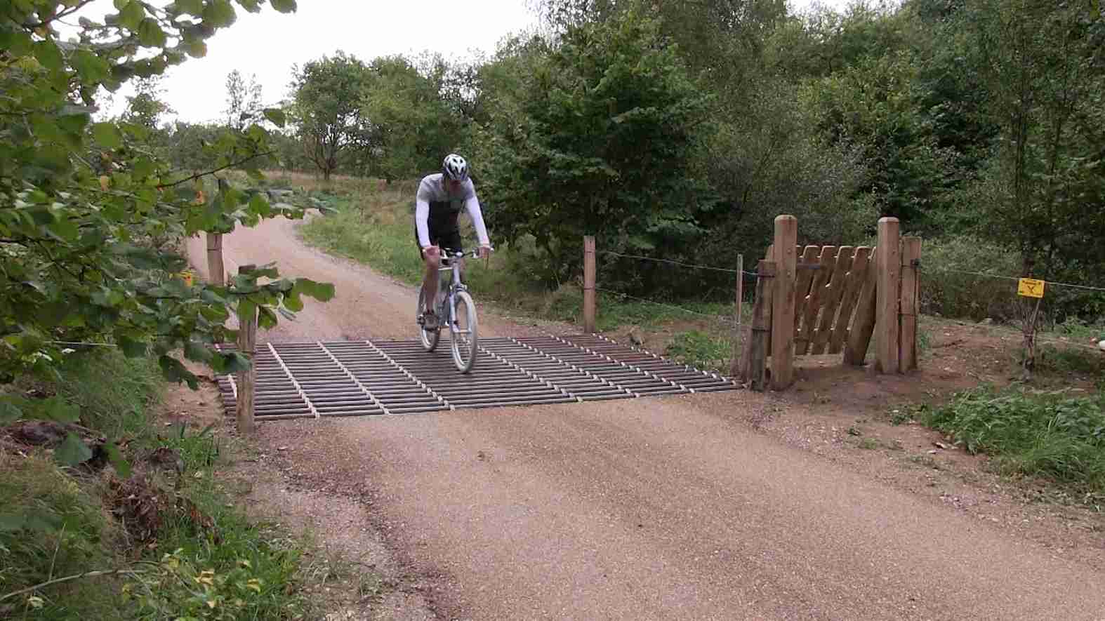 Een fietser rijdt over een veerooster